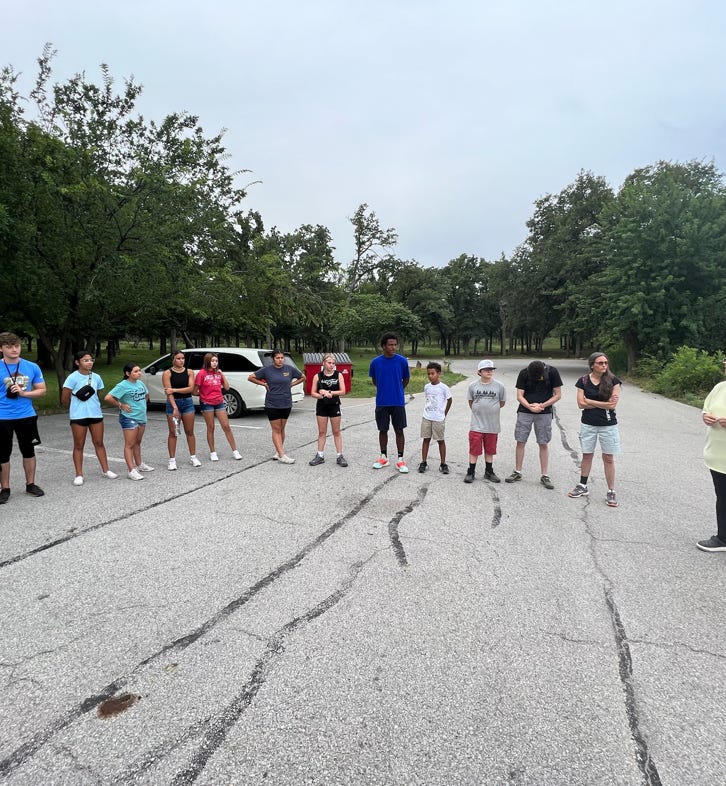 Members from the missions team leading a prayer circle before taking a hike in the Wichita Mountains with the local youth.